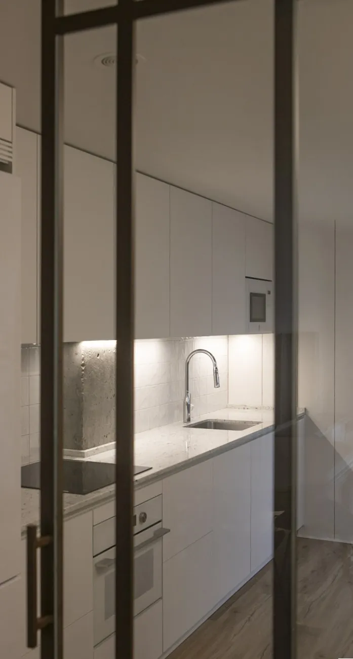 Detalle de la cocina donde la iluminación define las zonas de trabajo y almacenaje