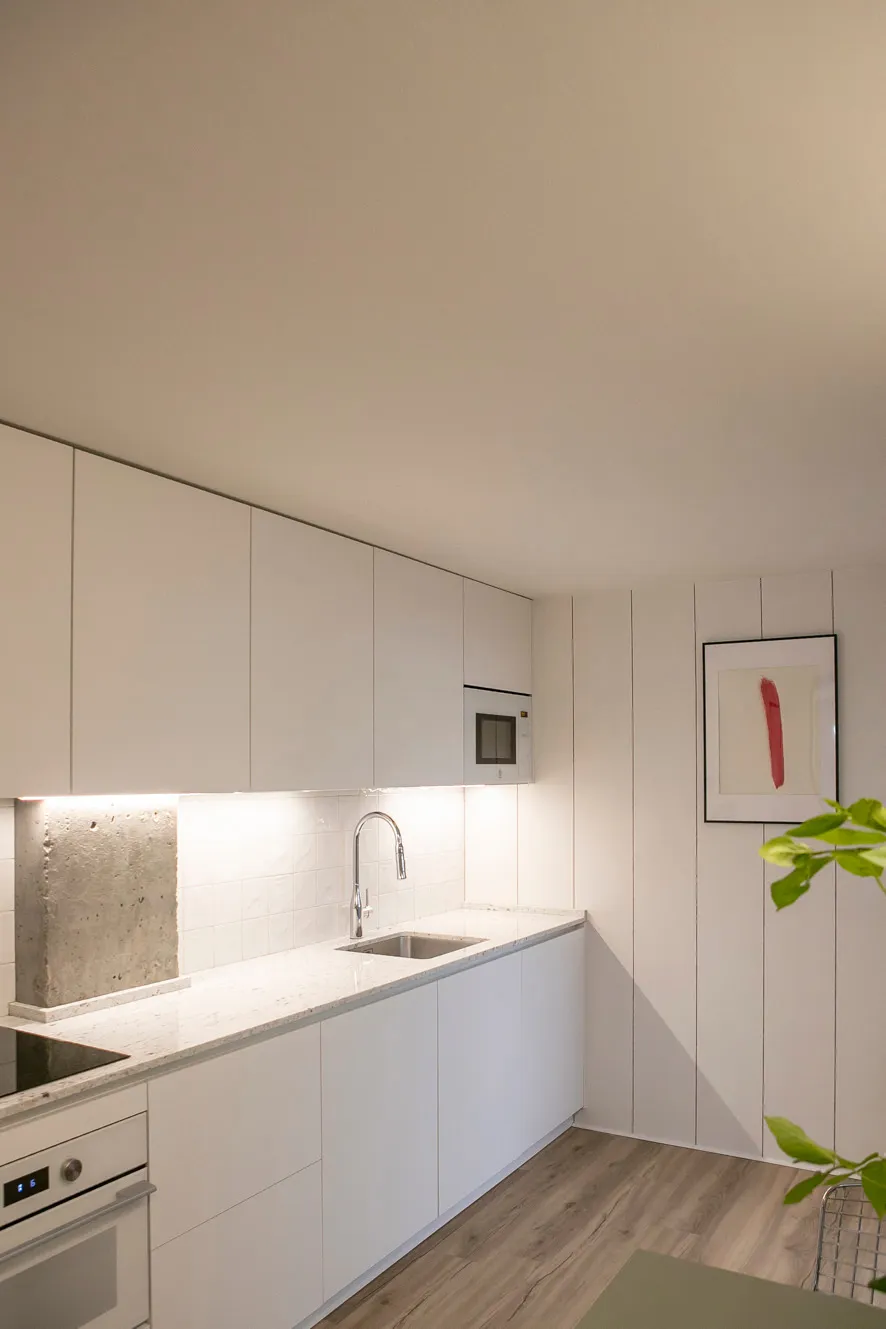 Cocina abierta al comedor con isla central y materiales que unifican el espacio