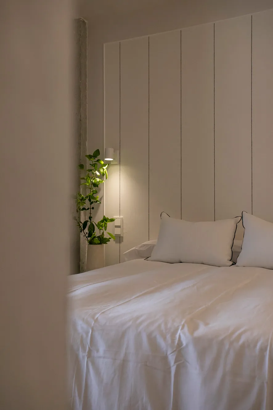 Detalle del dormitorio matrimonio con acabados en tonos neutros y textiles acogedores