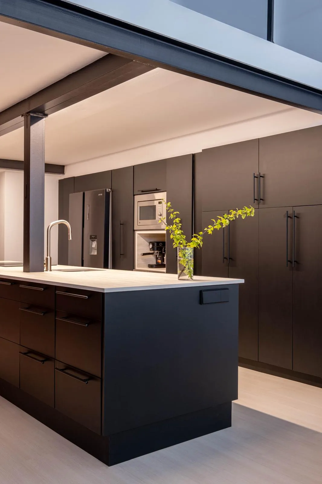 Reforma integral con cocina integrada en salón, isla central y materiales que combinan funcionalidad y estética