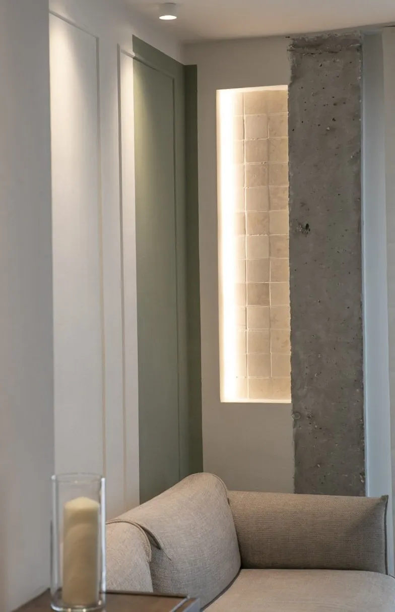 Rincón de lectura integrado en el salón con iluminación ambiental